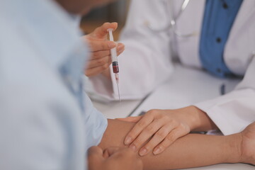 Doctor uses hypodermic needle and syringe to put a dose of medicine as treatment.