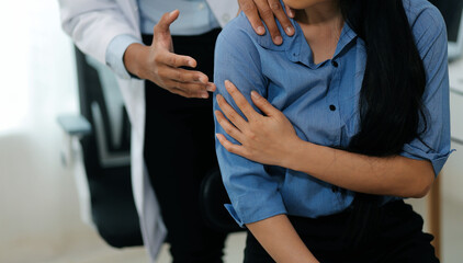 Doctor or Physiotherapist working examining treating injured arm of athlete male patient,...