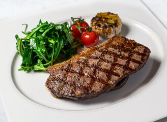 Grilled Wagyu Sirloin Steak with cherry tomato served in dish isolated on background side view of italian food