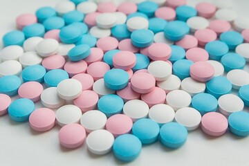 White, blue  and pink tablets scattering on the table