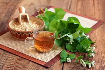 Herbal tea made from buckwheat seed, lat. Fagopyrum esculentum, fresh flowering plant next to it....