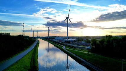 A stunning view of wind turbines at sunset, showcasing the harmony of renewable energy with natures beauty - Powered by Adobe