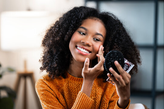 Beautiful black woman doing self make-up.