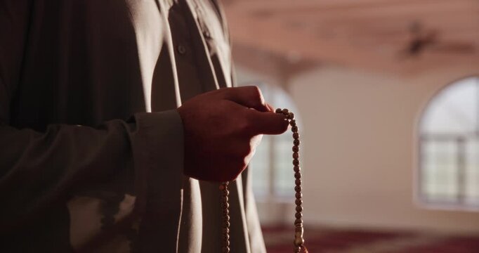 Islamic, hands and person with prayer beads for religion, worship and remember of Allah with verse recitation. Mosque, muslim man and praise with tasbih for faith, belief and spiritual with devotion