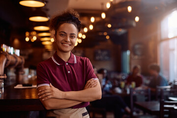 Confident waitress working in pub and looking at camera.