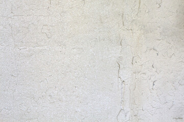 Close-up of a textured cracked white wall. Abstract grunge surface.