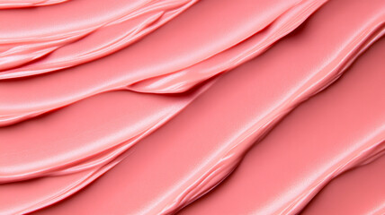 Closeup of a cream blush texture background in a coral pink hue, displaying creamy, smooth application with subtle sheen 