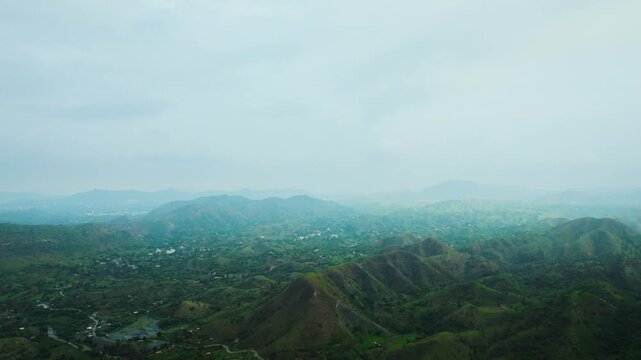 4K Aerial view of green hills and cloudy sky during monsoon season at Rayta, Udaipur, India. Foggy moody weather at hill station. Nature landscape.