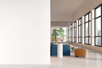 Modern office interior with a large blank white wall, open seating area and large windows. 3D...