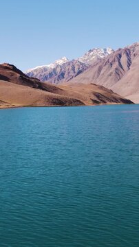 Vertical aerial shot of blue color Chandra Taal lake with Himalaya mountains in Spiti Valley, India. Beautiful aerial landscape of mountain lake. Travel, vacation and Holidays background.
