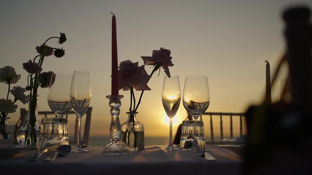 sunset on the beach Festive table setting candles for Wedding party and dinner setting table row chair flower reception party.
