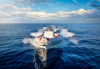 Front view of a sports RIB boat cruising with high speed over the blue sea