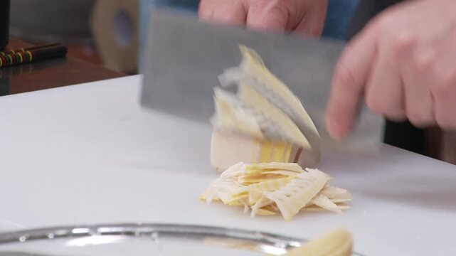 도마 위에서 칼로 삶은 죽순을 손질하는 모습