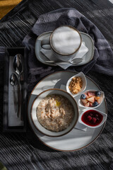 Porridge and coffee. Served breakfast in a cafe. Vertical photo.