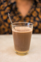 Cup of hot cocoa with condensed milk on table. Close up 