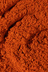 Ground paprika, red terracotta spice background, art in cooking.