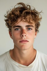 Naklejka premium Portrait of a young man with curly hair and freckles