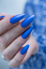 Woman's beautiful hand with long nails and bright blue manicure