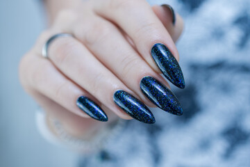 Woman's hand with long nails black and dark blue manicure