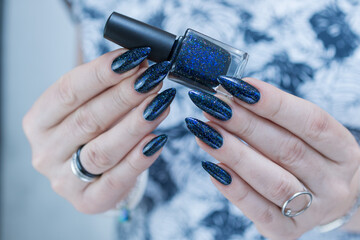 Woman's hand with long nails black and dark blue manicure