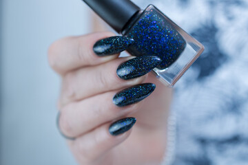 Woman's hand with long nails black and dark blue manicure