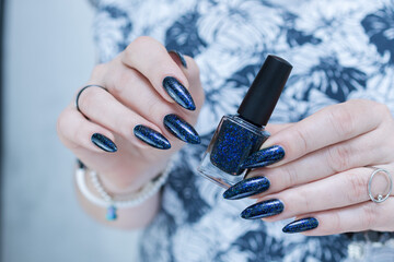 Woman's hand with long nails black and dark blue manicure