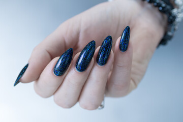 Woman's hand with long nails black and dark blue manicure