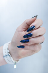 Woman's hand with long nails black and dark blue manicure