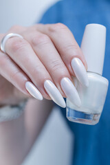 Woman's hands with long nails and a light white color nail polish