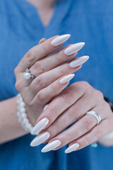 beautiful female hands with long nails light white manicure