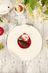 Chocolate Potato Pastry with Ice Cream and Raspberry Sauce on Sunlit Wooden Table