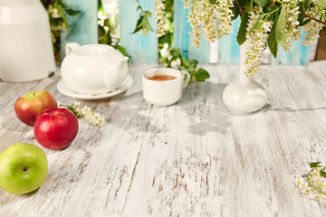 Summer Tea Party with Flowers and Sunlight on Rustic Wooden Table