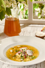 Refreshing Okroshka with Kvass and Sour Cream in Sunlit Wooden Setting