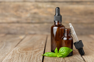 Basil essential oil on a textured wooden background. Basil essential oil and fresh leaves. Aromatherapy. Aroma oil. Medical herbs. Alternative medicine. Place for text. Copy space.