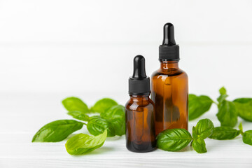 Basil essential oil on a textured wooden background. Basil essential oil and fresh leaves. Aromatherapy. Aroma oil. Medical herbs. Alternative medicine. Place for text. Copy space.