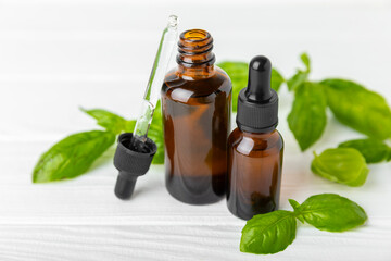 Basil essential oil on a textured wooden background. Basil essential oil and fresh leaves. Aromatherapy. Aroma oil. Medical herbs. Alternative medicine. Place for text. Copy space.