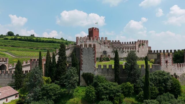 Aerial view of Soave castle, a historic fortress in italy, is standing majestically on a hilltop, surrounded by lush vineyards and the charming italian countryside