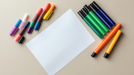 Naklejka premium Blank white paper with colorful markers surrounding it.