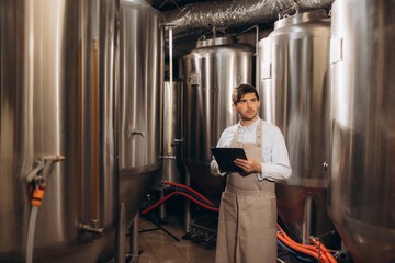 man at brewery taking notes on brewing process