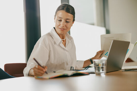 A Focused and Professional Woman Engaged in Tasks in a Modern Office Environment