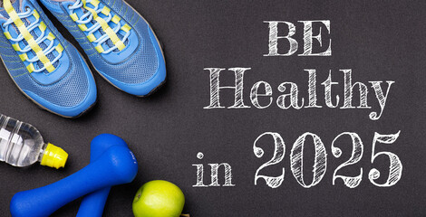 New year 2025 resolutions healthy lifestyle and sport. Be healthy in 2025. Motivation sport goals 2025 with sport equipment shoes, dumbbells, fruit and water bottle on black background