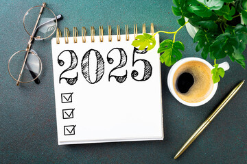 New year resolutions 2025 on desk. 2025 resolutions list with notebook, coffee cup on table. Goals, resolutions, plan, action, checklist concept. New Year 2025 template, copy space