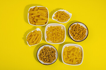 Pasta. Various kinds of uncooked pasta and noodles over wooden background