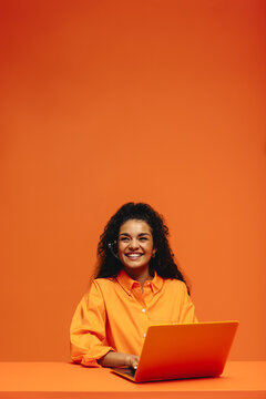 Smiling customer care representative in vibrant monochromatic office setting with headset and laptop