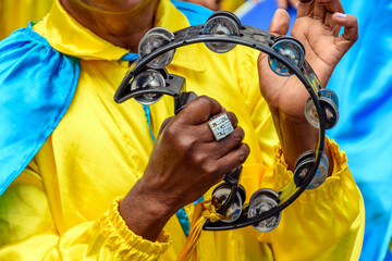 Tambourine player in colorful clothes during a performance at a traditional Brazilian religious festival © Fred Pinheiro