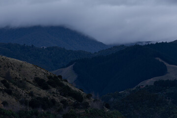 Foggy clouds rolling over the mountain top.