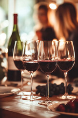 Naklejka premium Wine glasses on a table with people in background