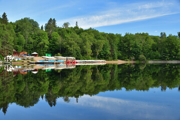 Canoe and kayak rental buisiness. Calm day on Wapizagonke lake Canada Park La Mauricie, Quebec, Canada. Lots of paddling boat on lake shore.