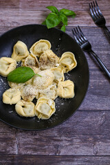 Home made vegetarian  italian   Tortellini with pesto genovese filled with   spinach   and parmesan cheese, decorated with fresh basil