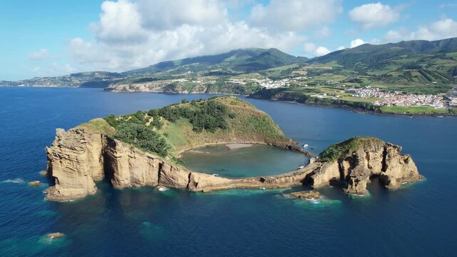 Aerial view of Ilheu de Vila Franco do Campo on a bright summer day, showcasing its turquoise lagoon and volcanic beauty off Sao Miguel, Azores, Portugal